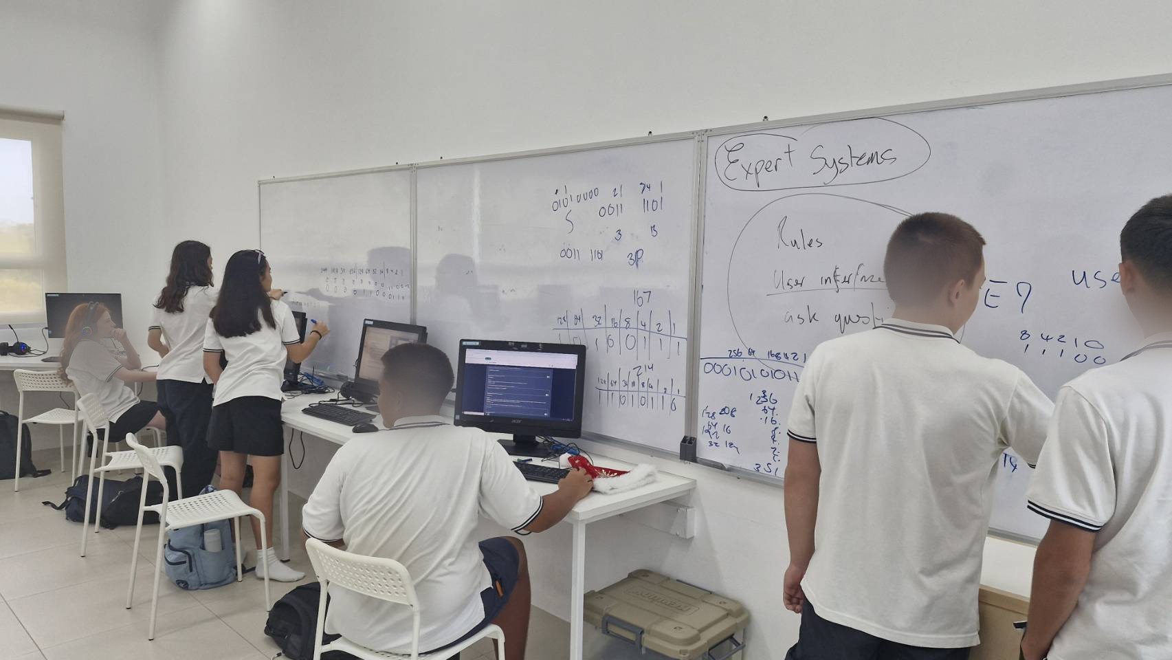 An IGCSE Computer Science class using ReviseWell, with an 'Expert Systems' topic on the whiteboard. Student faces blurred for privacy.
