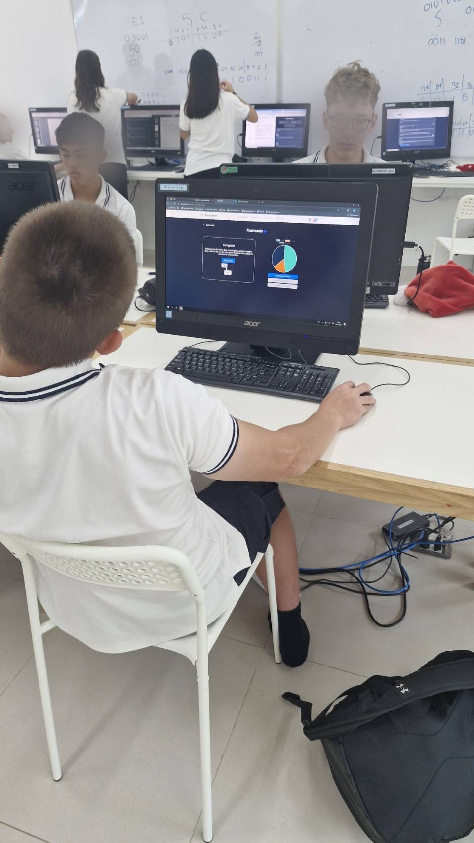 A student reviewing a ReviseWell topic breakdown and flashcards on a classroom computer. Face blurred for privacy.